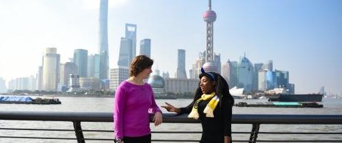 Students standing in front of Shanghai skyline during the day
